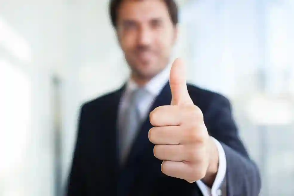 A man giving the thumbs up sign in front of him.