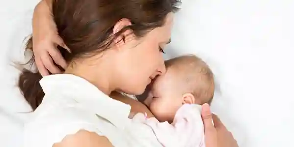 A woman holding her baby in her arms.