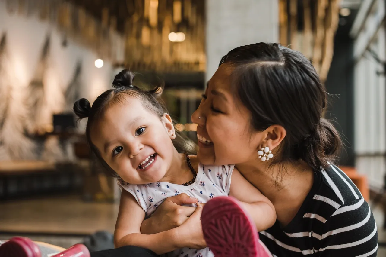 A woman holding a child and smiling.