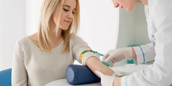 A woman getting her arm examined by an doctor.