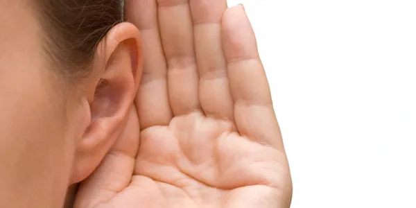 A person 's ear and hand with the palm up.