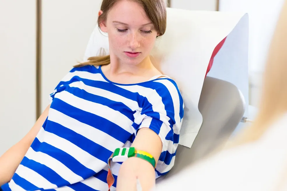 A woman is sitting in the hospital bed