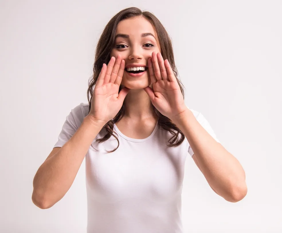 A woman with her hands over her mouth.