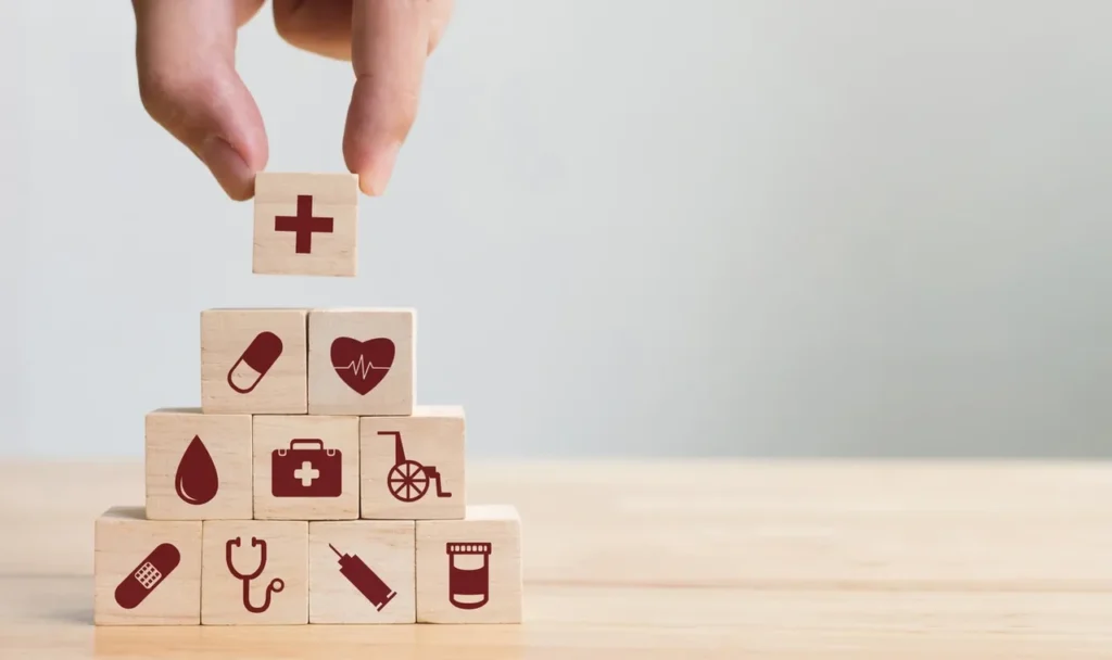 A hand is holding onto blocks with medical symbols on them.