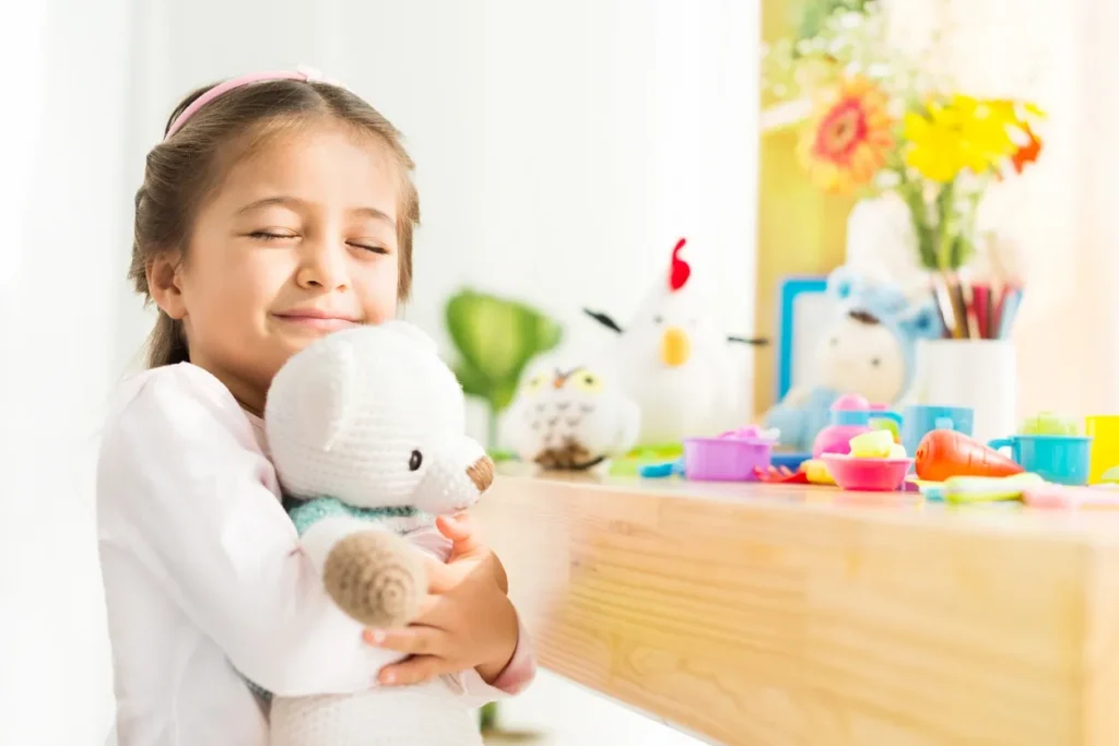 A little girl holding onto a teddy bear