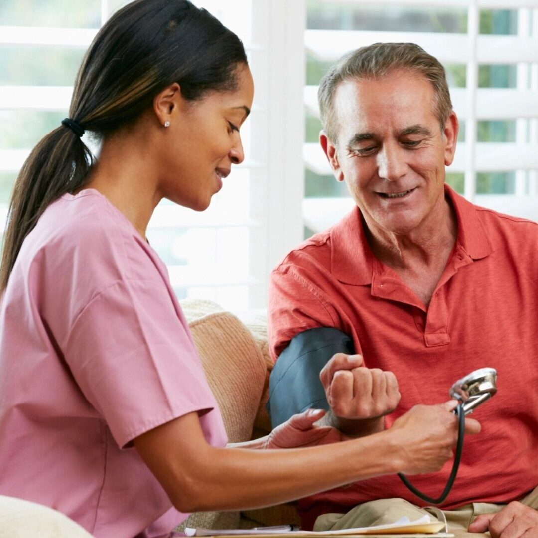 A nurse checking the blood pressure of an older man.