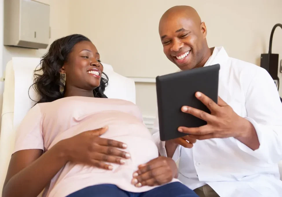 A man and woman looking at an ipad.