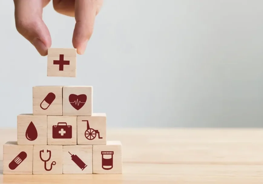 A hand is holding onto blocks with medical symbols on them.